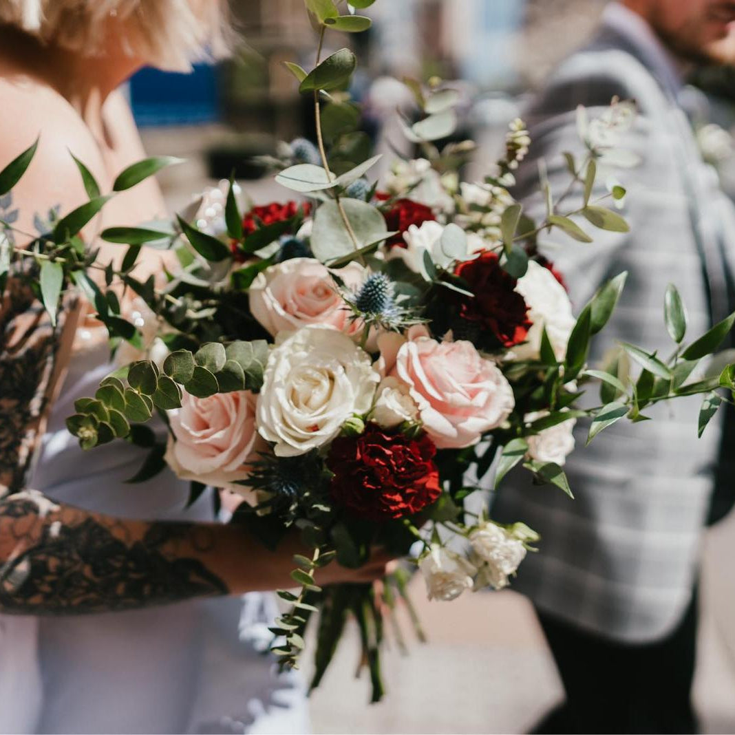 Person holding a bouquet of flowers with a blurred background